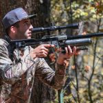 hunter carrying ab air rifle through the woods as he looks for prey